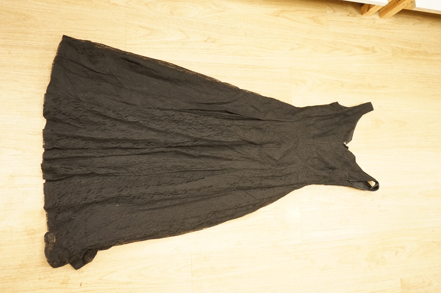 A late 1940’s black lace evening dress, a similar evening dress with black velvet ribbon detail, a maroon brocade halter neck evening dress and a dark mustard early 1950’s evening silk duster coat.